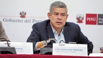 Luis Galarreta sentado ante micrófonos y un cartel con su nombre frente a un panel del Gobierno de Perú