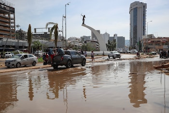 Vehicles drive on flooded streets