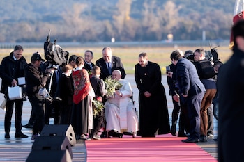 El Papa Francisco recibe un ramo de flores de un niño al ser recibido en el Aeropuerto Napoleón Bonaparte de Ajaccio durante su viaje apostólico en Córcega (REUTERS/Remo Casilli)