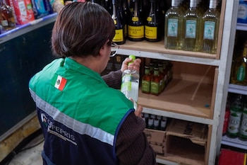 Personal de COFEPRIS inspeccionando el las botellas de alcohol. Crédito: SSC