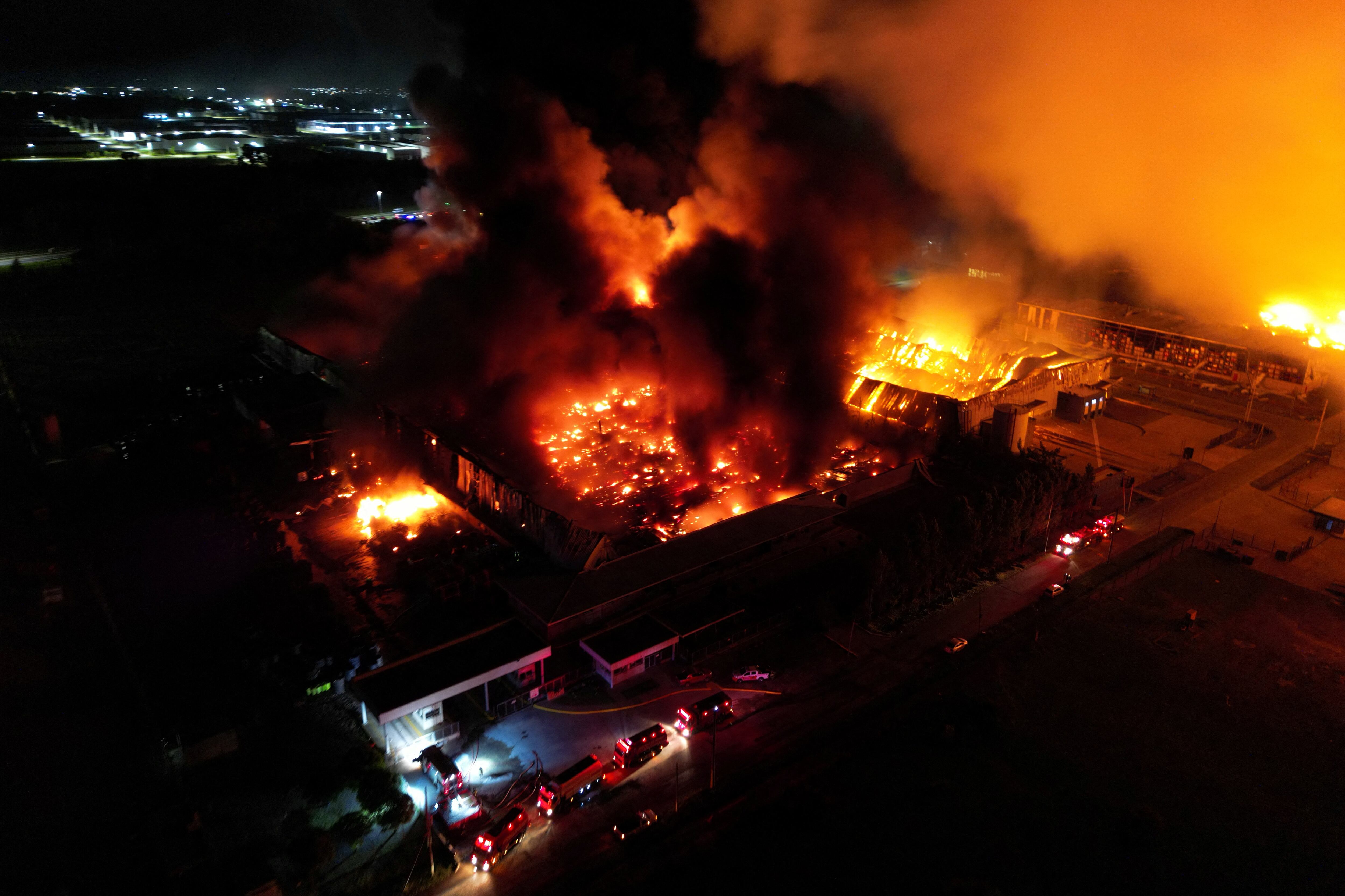 Vista aérea del incendio en el polo industrial de Carlos Spegazzini (Photo by Luis ROBAYO / AFP)