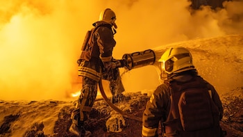 Dos bomberos en medio del