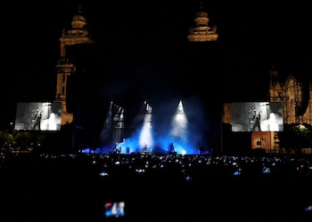Fans record with their mobile phones as the American rock band Interpol performs during a free concert at Mexico City's Zocalo main square, Mexico, Saturday, April 20, 2024. The Cathedral Metropolitana is seen at the background. REUTERS/Henry Romero