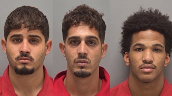 Tres fotografías policiales de tres hombres jóvenes vestidos con camisetas rojas sobre un fondo gris.