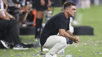 Pablo Guede, acuclillado mientras visualiza con detenimiento un partido de Alianza Lima. - Crédito: Andina