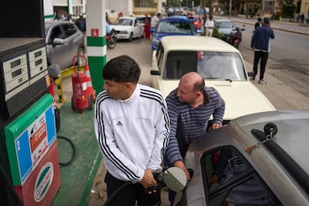 Personas repostan en una gasolinera