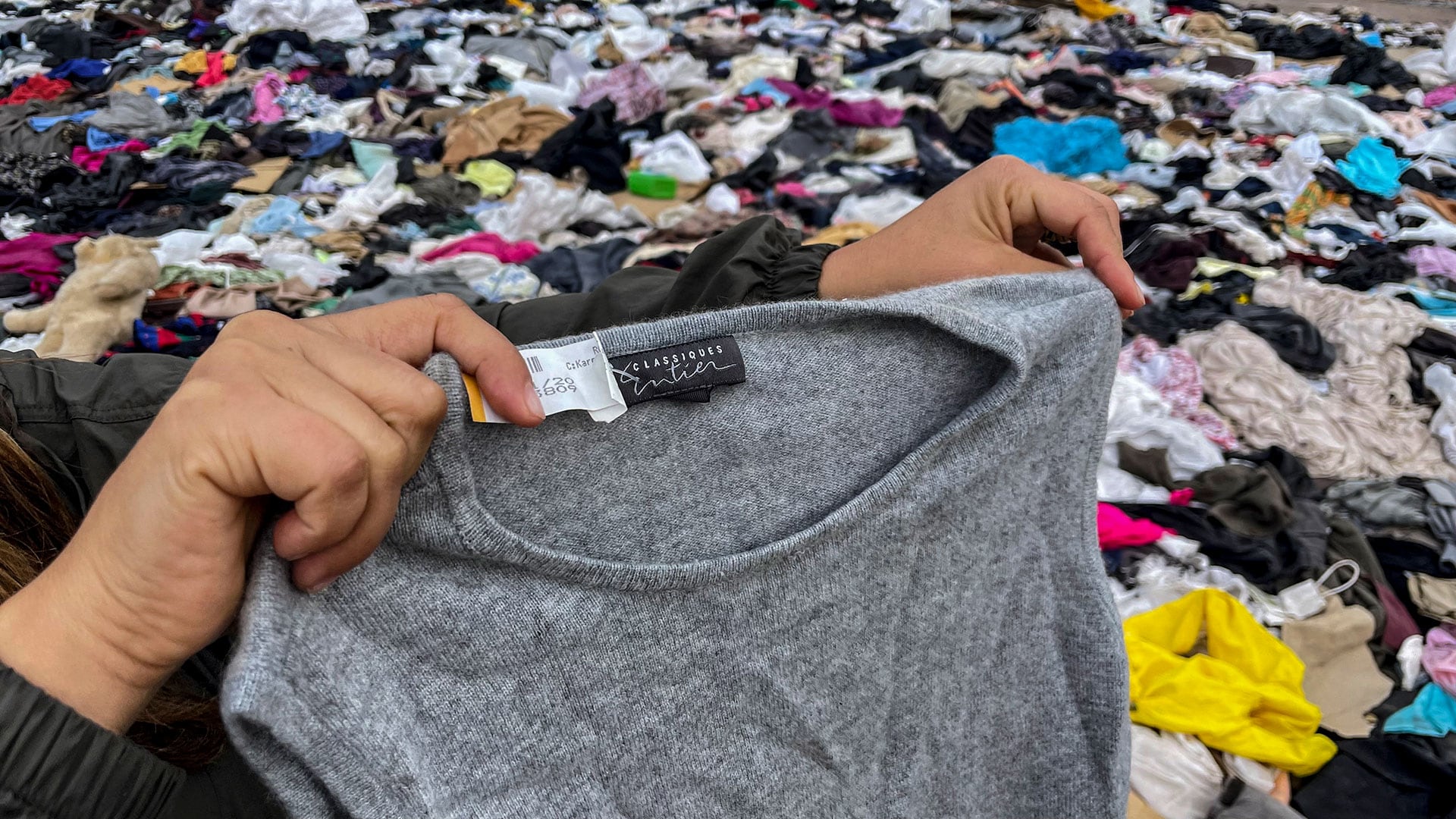 Una mujer busca ropa usada entre toneladas de prendas desechadas en el desierto de Atacama, en Alto Hospicio, Iquique, Chile, el 26 de septiembre de 2021.(MARTIN BERNETTI / AFP)
