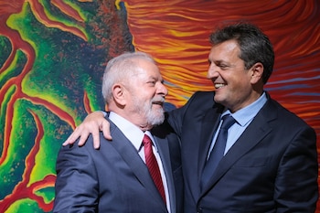 Sergio Massa rodea con su brazo los hombros de Luiz Inácio Lula da Silva mientras ambos sonríen ante una pintura de colores intensos