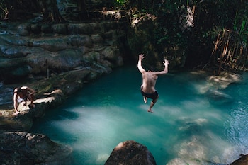 Un hombre saltando a una piscina natural (Magnific)