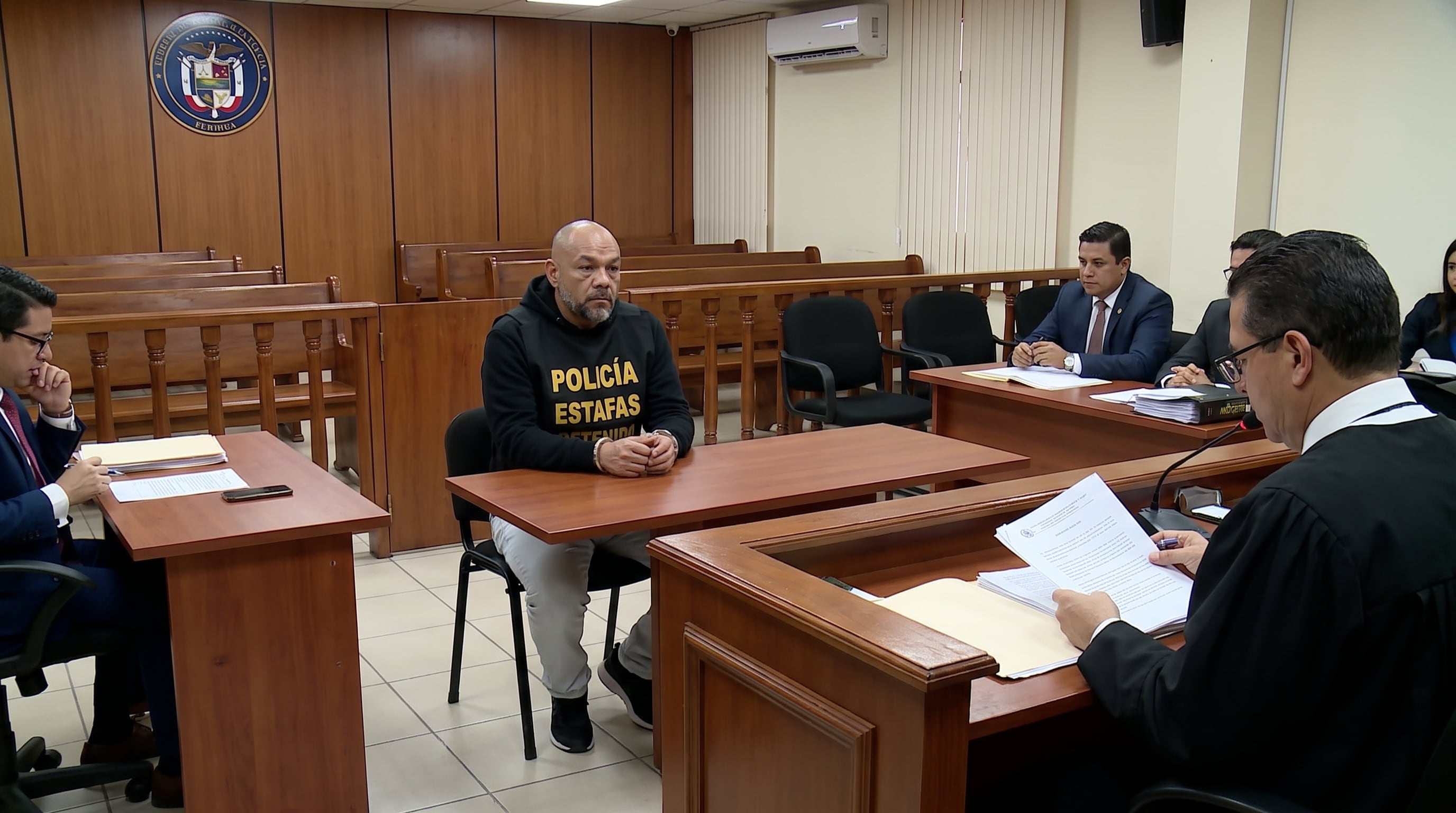 Jackson Mora asiste a una audiencia judicial con las manos esposadas, mientras un juez revisa los documentos antes de dictar la decisión sobre su sentencia. (Imagen Ilustrativa Infobae)