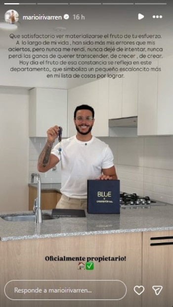 Un hombre sonriente con anteojos sostiene un juego de llaves junto a la mesada de una cocina blanca y de madera