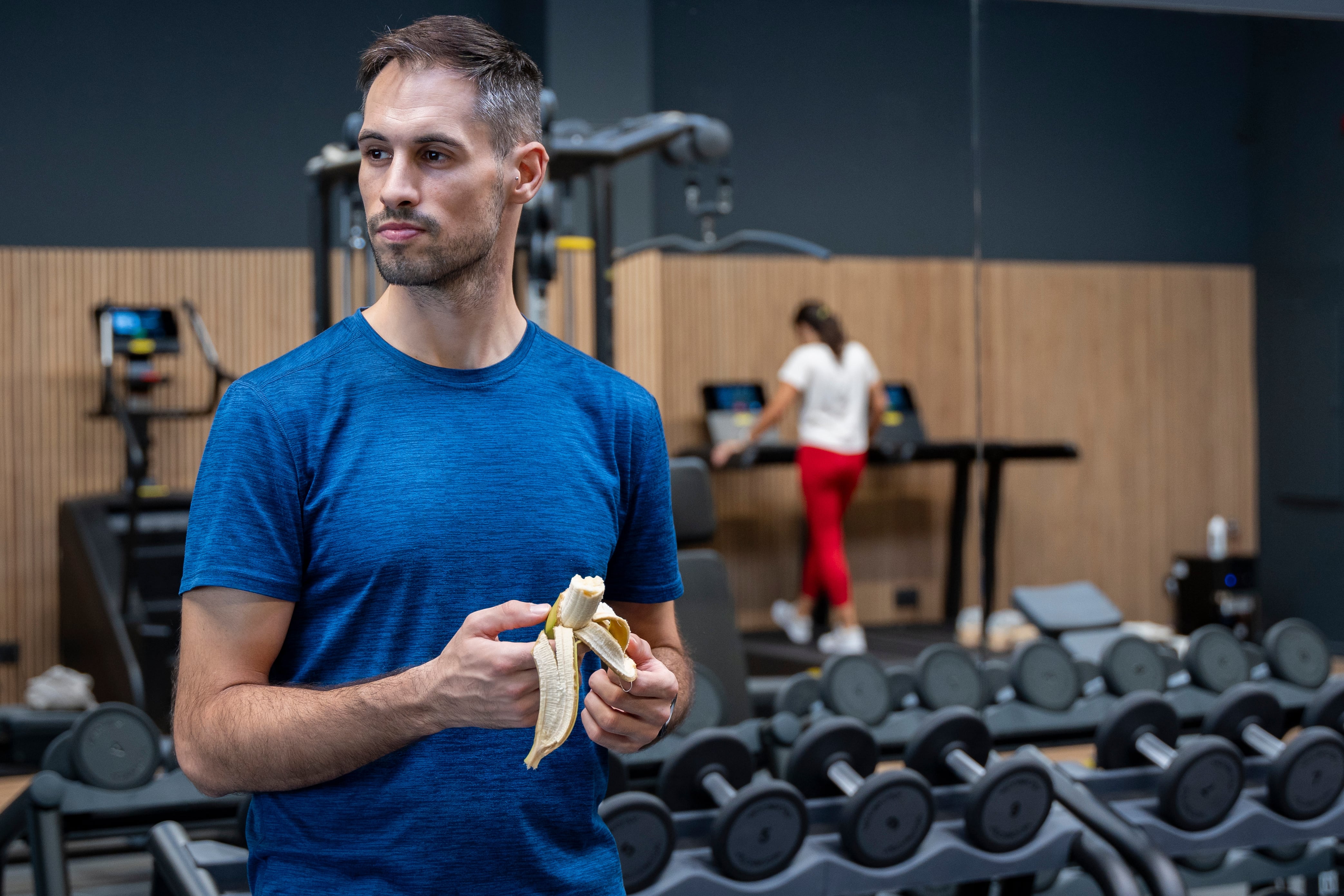 Un hombre se come un plátano en un descanso en el gimnasio (AdobeStock)
