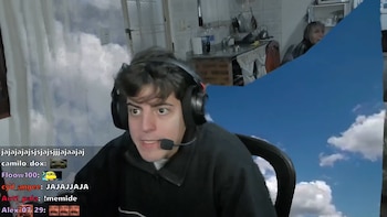 Un joven con auriculares frente a un fondo digital de cielo que se corta y deja ver una cocina de fondo con utensilios y una persona sentada