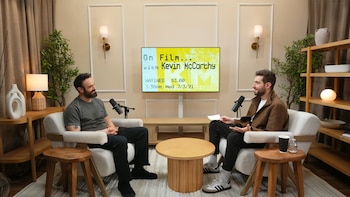 Dos hombres, Charlie Cox y Kevin McCarthy, sentados en sillones frente a una pantalla de TV y micrófonos en un estudio de podcast