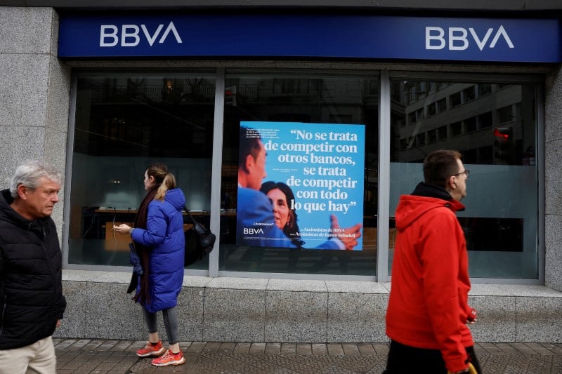 Gente pasa junto a una sucursal del banco BBVA (REUTERS/Vincent West)