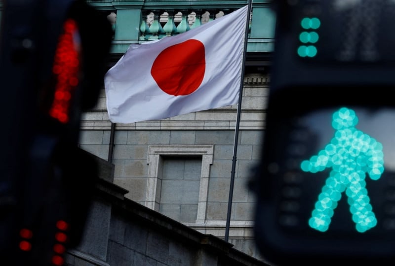 La bandera nacional japonesa ondea en la sede del Banco de Japón entre semáforos en Tokio, Japón. 23 de enero de 2025. REUTERS/Issei Kato