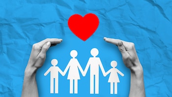 Dos manos rodean siluetas de papel de una familia de cuatro integrantes bajo un corazón rojo, sobre un fondo azul arrugado