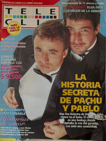 Dos hombres vestidos con esmoquin negro posan juntos en la portada de una revista con titulares impresos en amarillo y blanco