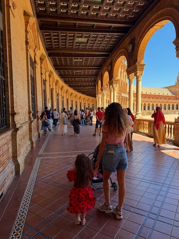 Melody y Venezia -vestida para la ocasión- recorriendo la galería de arcos de la Plaza de España