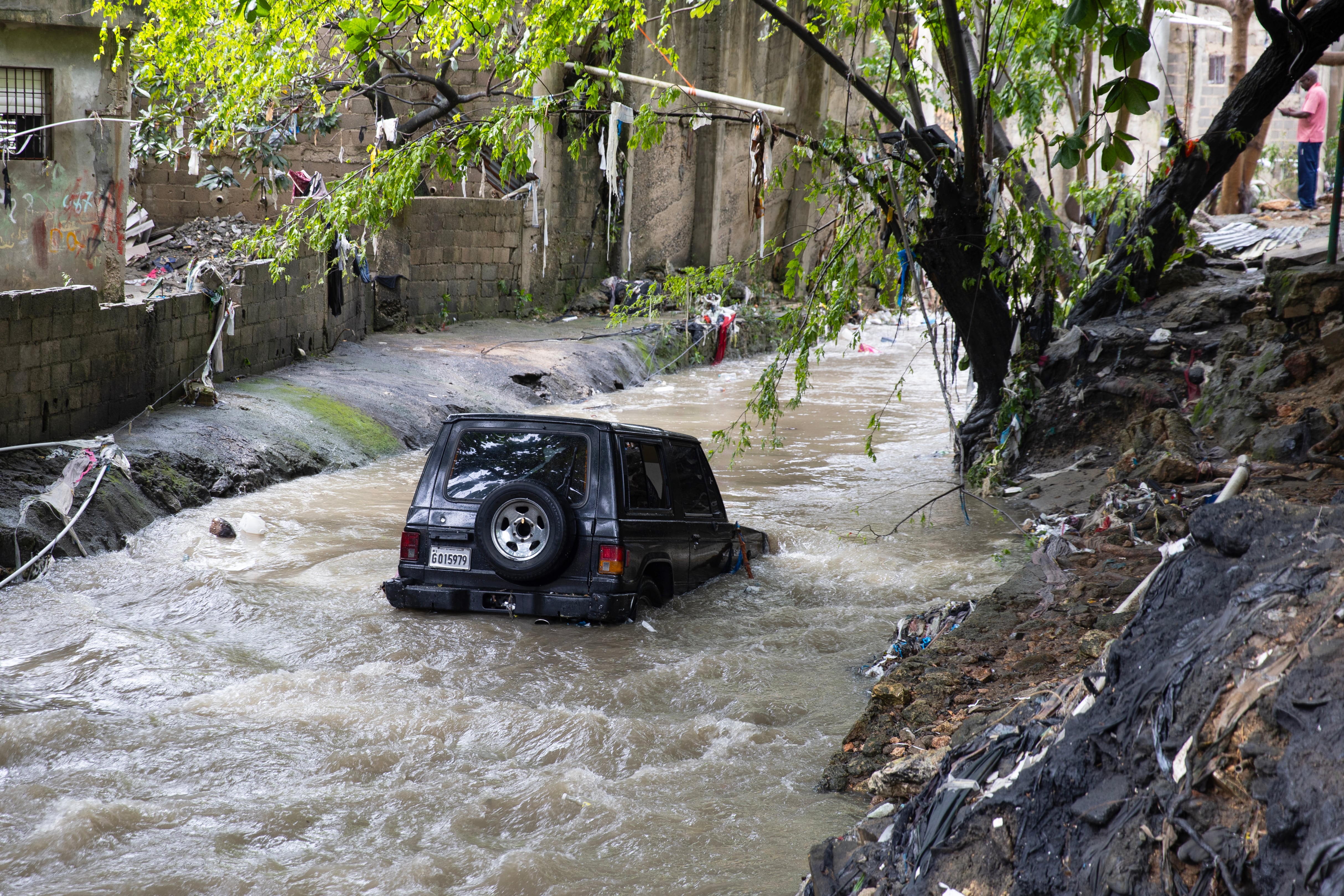 Fotografía que muestra un vehículo arrastrado a una cañada este miércoles en un barrio humilde en Santo Domingo (República Dominicana), que ha sufrido graves inundaciones a causa de las torrenciales lluvias arrojadas por una vaguada que incide sobre gran parte del país. EFE/Orlando Barría