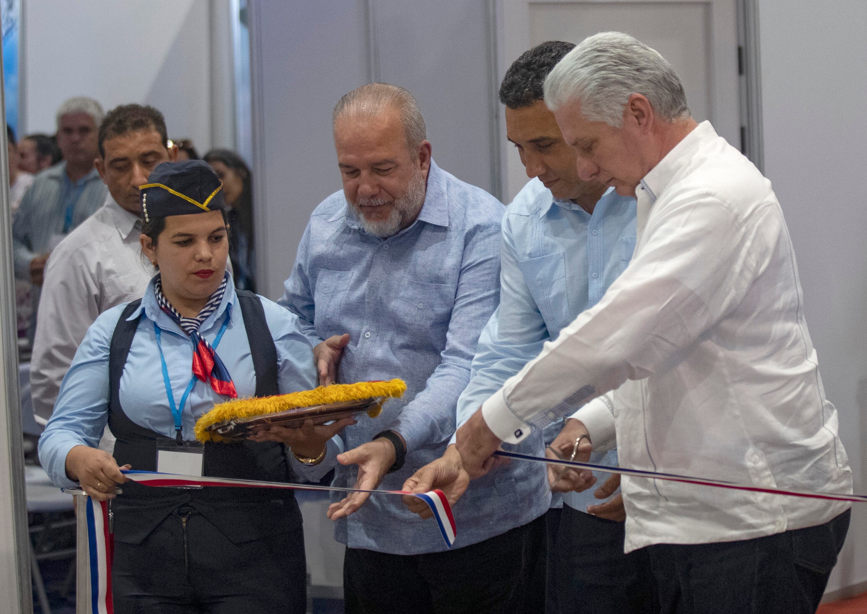 El presidente de Cuba, Miguel Díaz-Canel (d); el primer ministro, Manuel Marrero (c), y el titular de Transporte de Cuba, Eduardo Rodríguez (2-d), cortan la cinta inaugural de la II Feria Internacional del Transporte, en el recinto ferial Pabexpo, en La Habana (Cuba) (EFE/Yander Zamora)
