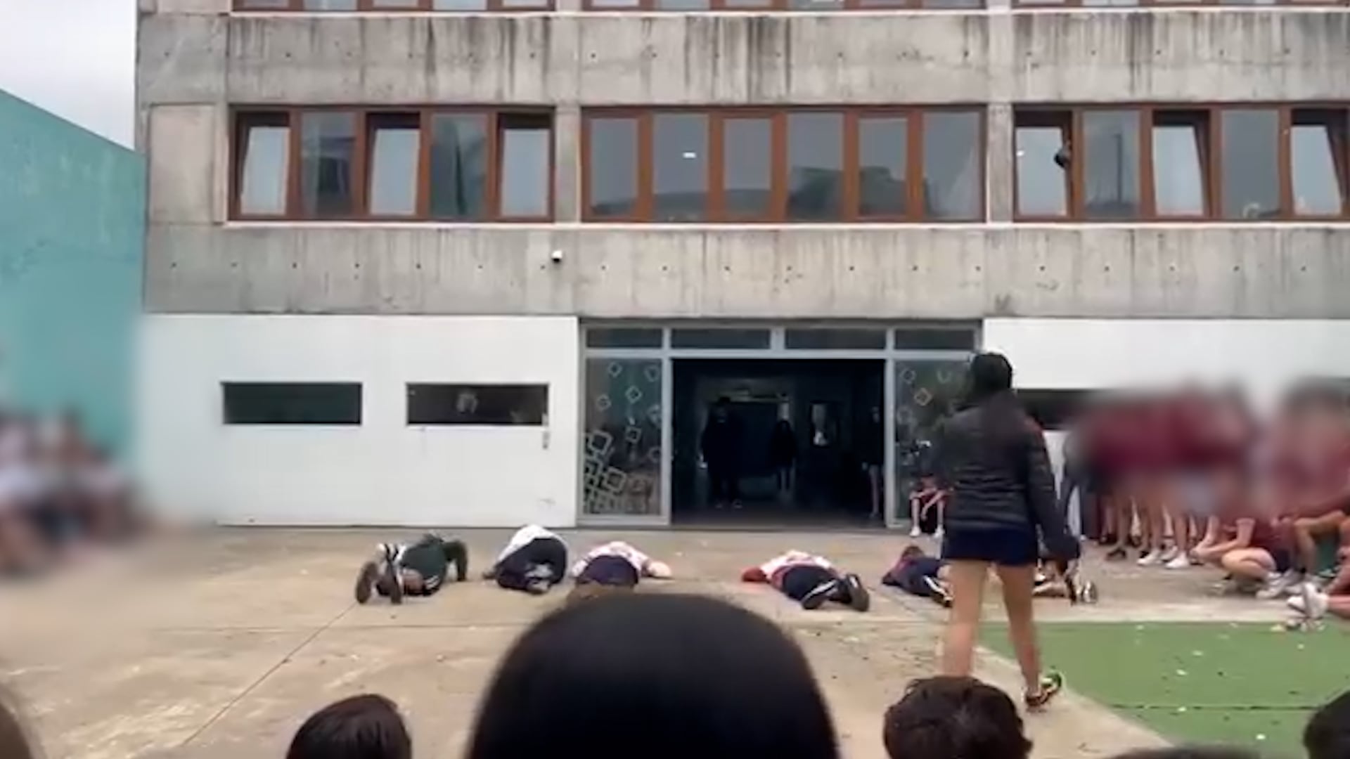 El momento en que una egresada simula el fusilamiento de seis compañeros, minutos antes de presentar sus buzos de egresados.