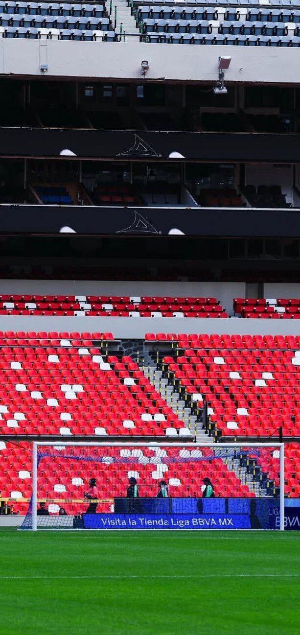 Las nuevas butacas rojas y blancas del Estadio Banorte se aprecian en las gradas del estadio de fútbol mientras los trabajos de remodelación continúan antes del inicio de la temporada. (X/ @MXESTADIOS)
