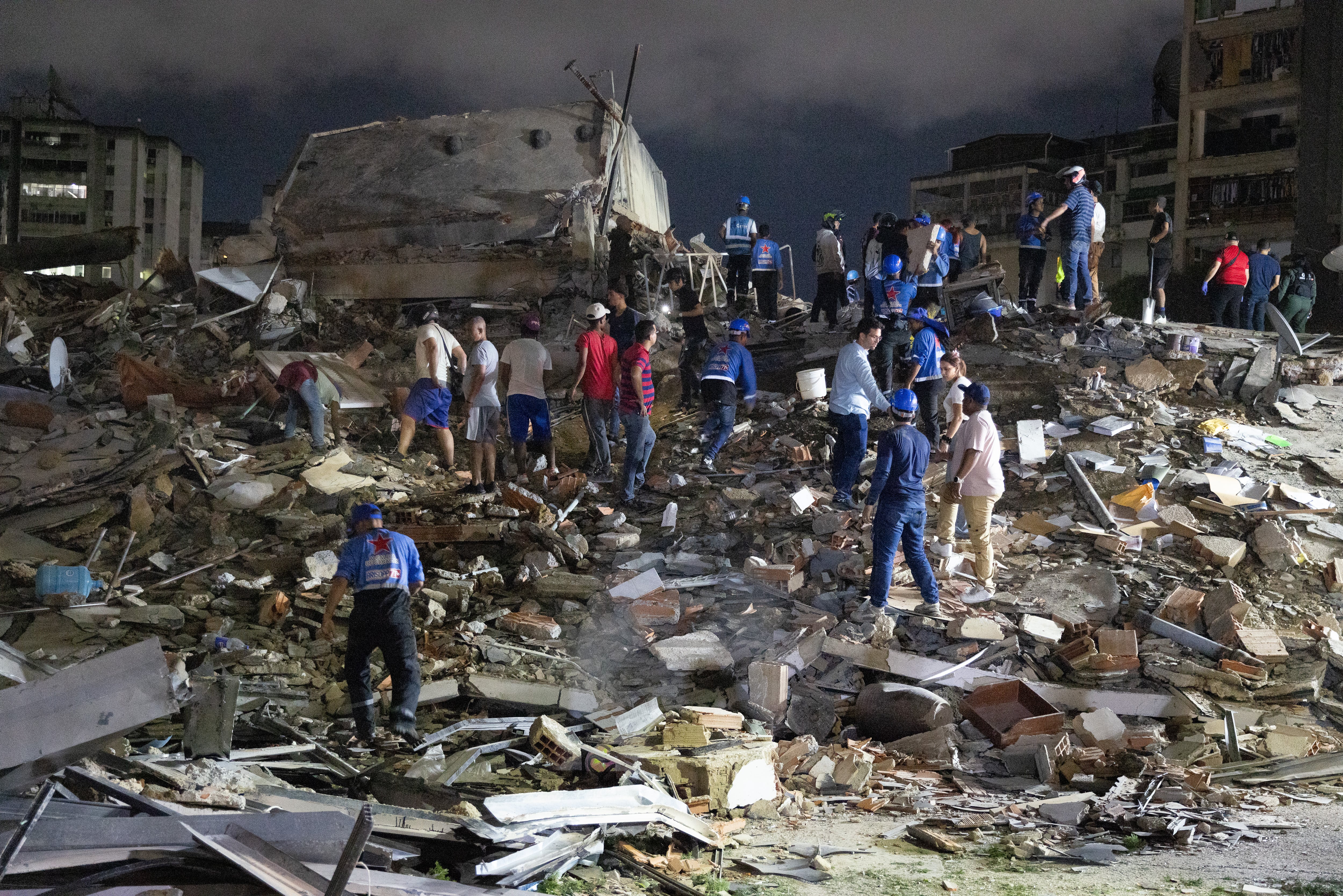 Integrantes de cuerpos de emergencia buscan víctimas este miércoles, luego de dos fuertes terremotos sacudieron el Caribe venezolano en Caracas, Venezuela. (EFE/ Rayner Peña)