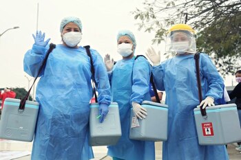 Profesionales de salud llevando vacunas.