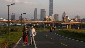 Personas usando mascarillas caminan en