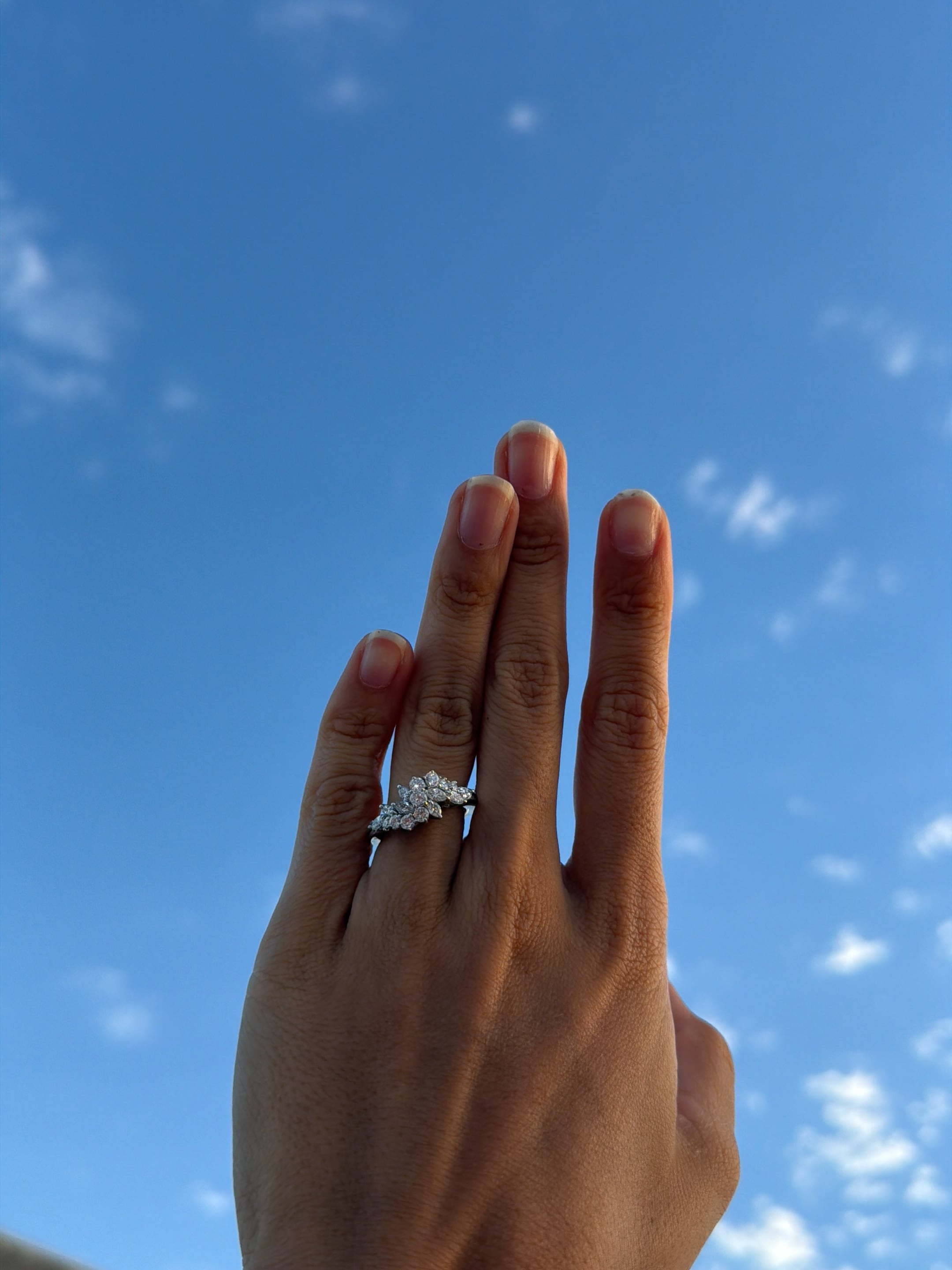 La periodista Morena Beltrán luce un anillo de compromiso en su mano alzada contra el cielo azul