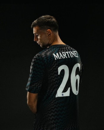 Un hombre de espalda viste una camiseta deportiva oscura con el apellido Martinez y el número 26 estampados en color blanco