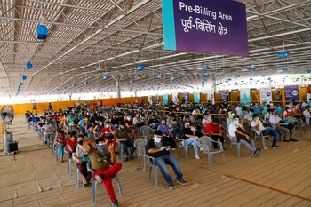 Personas con mascarillas protectoras esperan