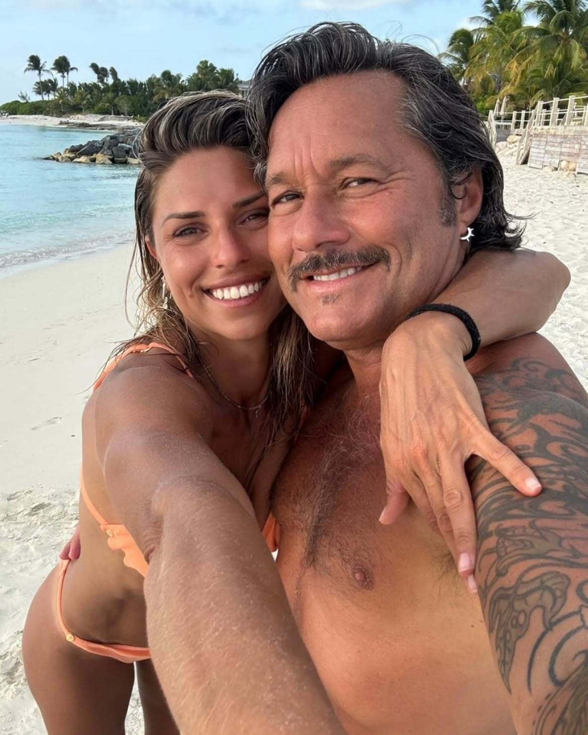 Diego Torres y Martina Díaz Radonic, en un retrato de pareja con el mar caribeño de fondo y expresión distendida