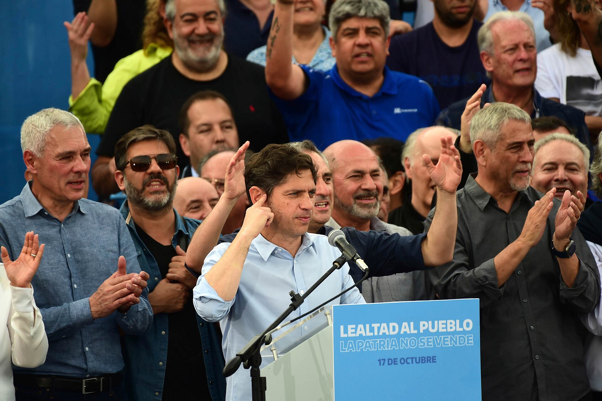 Axel Kicillof, en el acto de 2024 por el 17 de octubre; arriba, los sindicalistas Héctor Daer, Pablo Moyano y Andrés Rodríguez