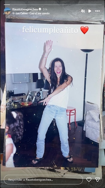 Mujer con camiseta blanca y jeans claros sonriendo con los brazos levantados en un interior. Fondo con muebles. La imagen incluye el texto 'felicummpleañito'