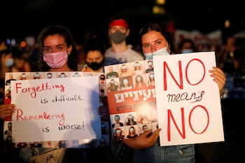 "Olvidarlo es difícil, recordarlo es peor", dice el cartel que exhibe uns manifestante, mientras que su compañera dice que "NO significa NO" (Reuters)