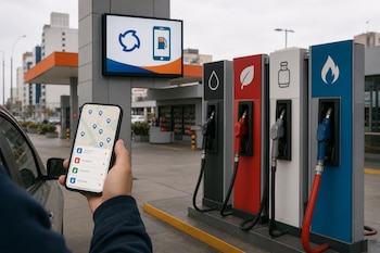 Mano que sostiene un teléfono móvil con un mapa frente a cuatro surtidores de combustible de colores negro, rojo, blanco y azul.