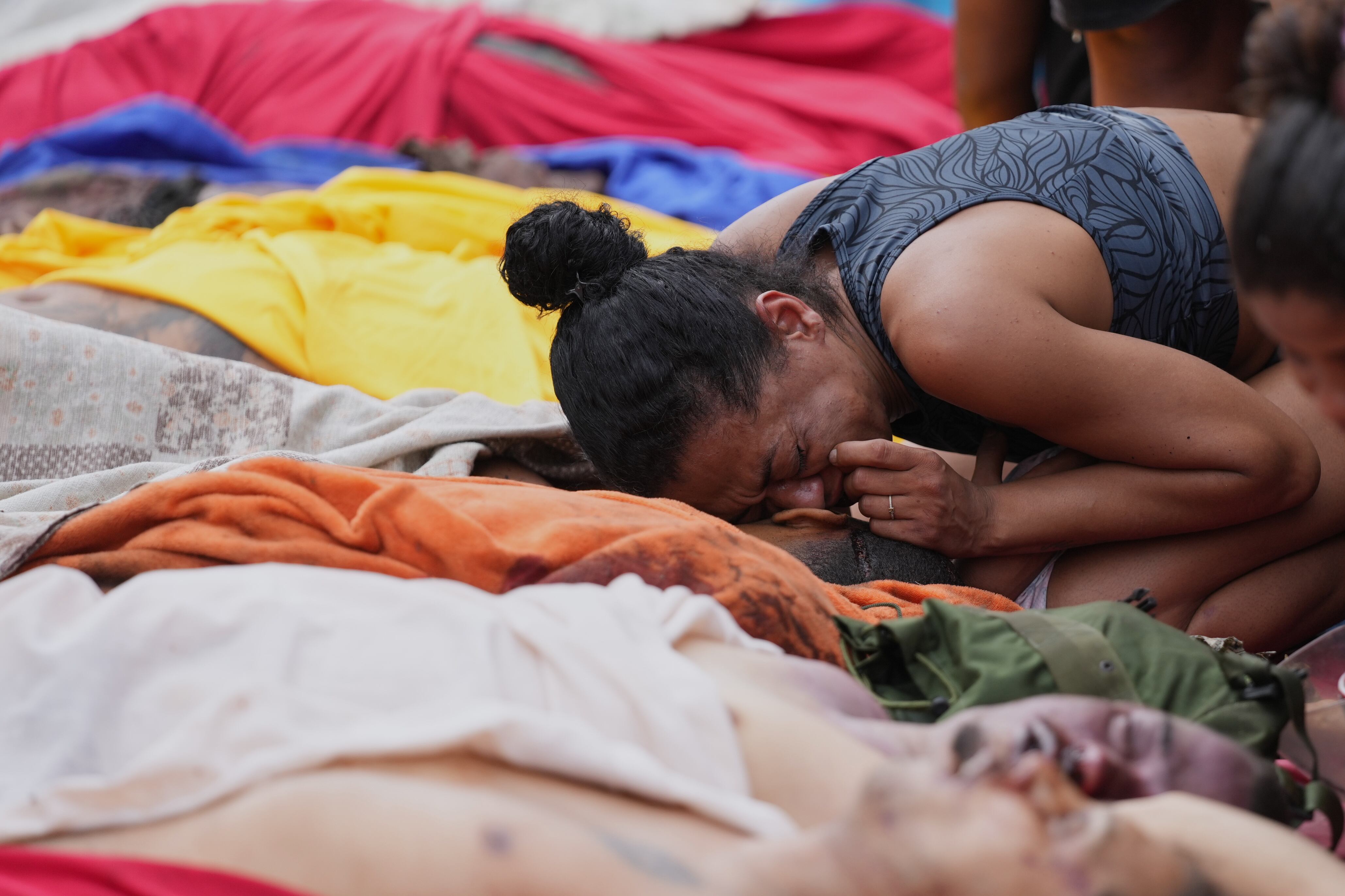 Una mujer llora sobre los cuerpos de las personas asesinadas el día anterior durante una redada policial contra la pandilla Comando Vermelho en la favela Complexo da Penha de Río de Janeiro, Brasil, el miércoles 29 de octubre de 2025 (AP Foto/Silvia Izquierdo)