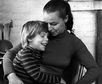 Una foto en blanco y negro muestra a Julie Patz, una mujer de cabello recogido, sosteniendo en sus brazos a un niño rubio, Etan Patz, ambos riendo
