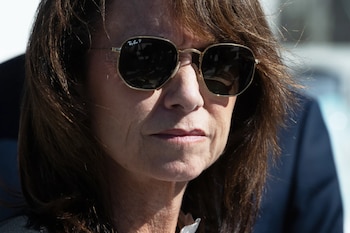 Primer plano de una mujer de mediana edad con cabello castaño, usando gafas de sol Ray-Ban, con una expresión seria bajo la luz del sol