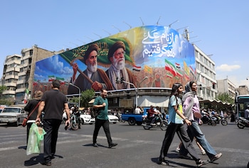 Ciudadanos iraníes pasan junto a una gran valla publicitaria en Teherán (EFE/EPA/ABEDIN TAHERKENAREH)