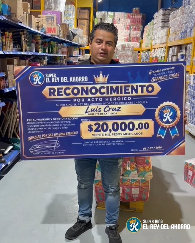 Luis Enrique Cruz sostiene un premio de 20 mil pesos otorgado por la tienda Super King El Rey del Ahorro en Puebla tras evitar el atropellamiento de una niña. (Facebbok)