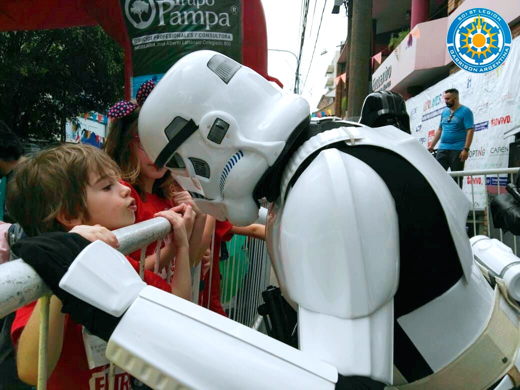 Un niño con cabello castaño claro observa con fascinación a un cosplayer de Stormtrooper en un evento de Star Wars (Legión 501 Garrison Argentina)