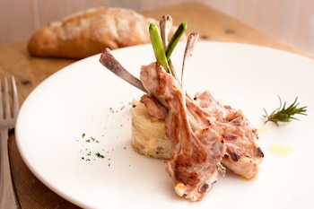 Chuletillas de cordero lechal a la parrilla con ajetes y patatas, del restaurante Las Musas (Web del restaurante)