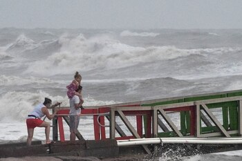 Una familia observa las altas olas del huracán Hanna desde un muelle en Galveston, Texas, EEUU, el 25 de julio, 2020. REUTERS/Adrees Latif