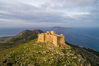 La estructura del castillo destaca entre la vegetación mediterránea de la isla siciliana