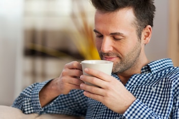Un joven tomando un café en la mañana (Freepik)