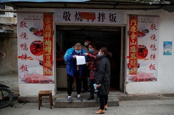 Members of a neighbourhood committee register a local and ask about his travel history in Jiujiang, Jiangxi province, China, as the country is hit by an outbreak of novel coronavirus. February 2, 2020. REUTERS/Thomas Peter