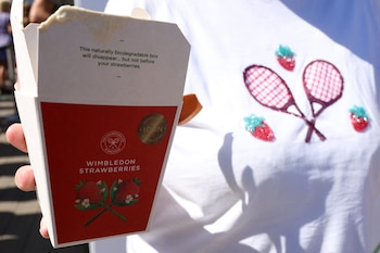 Tennis - Wimbledon - All England Lawn Tennis and Croquet Club, London, Britain - June 30, 2025 A spectator holds a box of strawberries and creams at Wimbledon REUTERS/Toby Melville